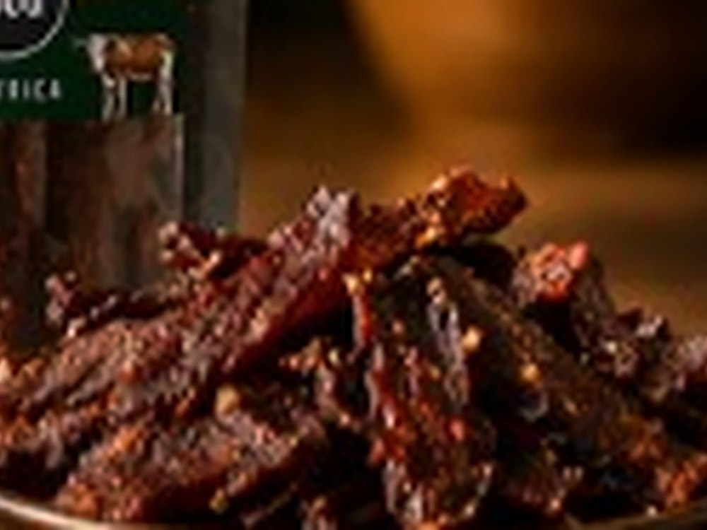African Farm & Gardens Kilishi Strips spiced dried beef served in a wooden bowl